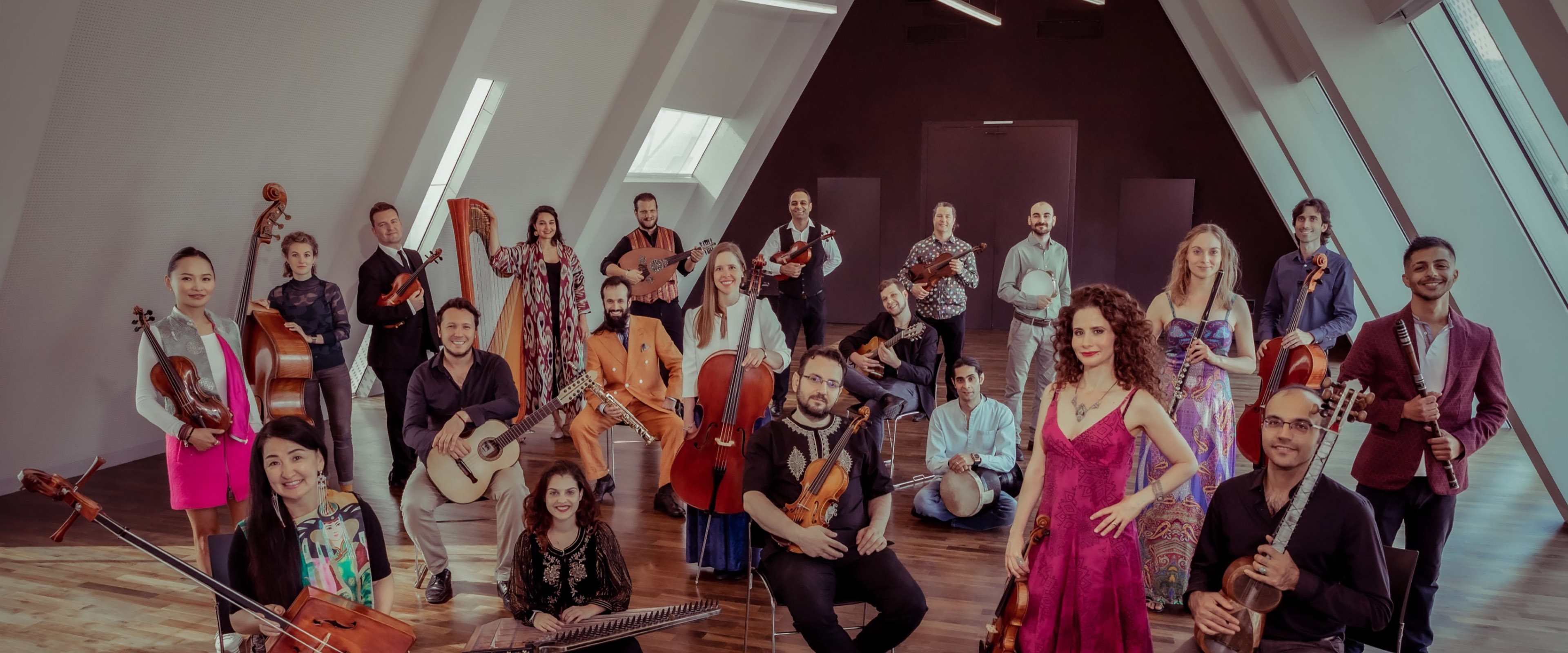 Gruppe von bunt gekleideten Menschen mit Streichinstrumenten