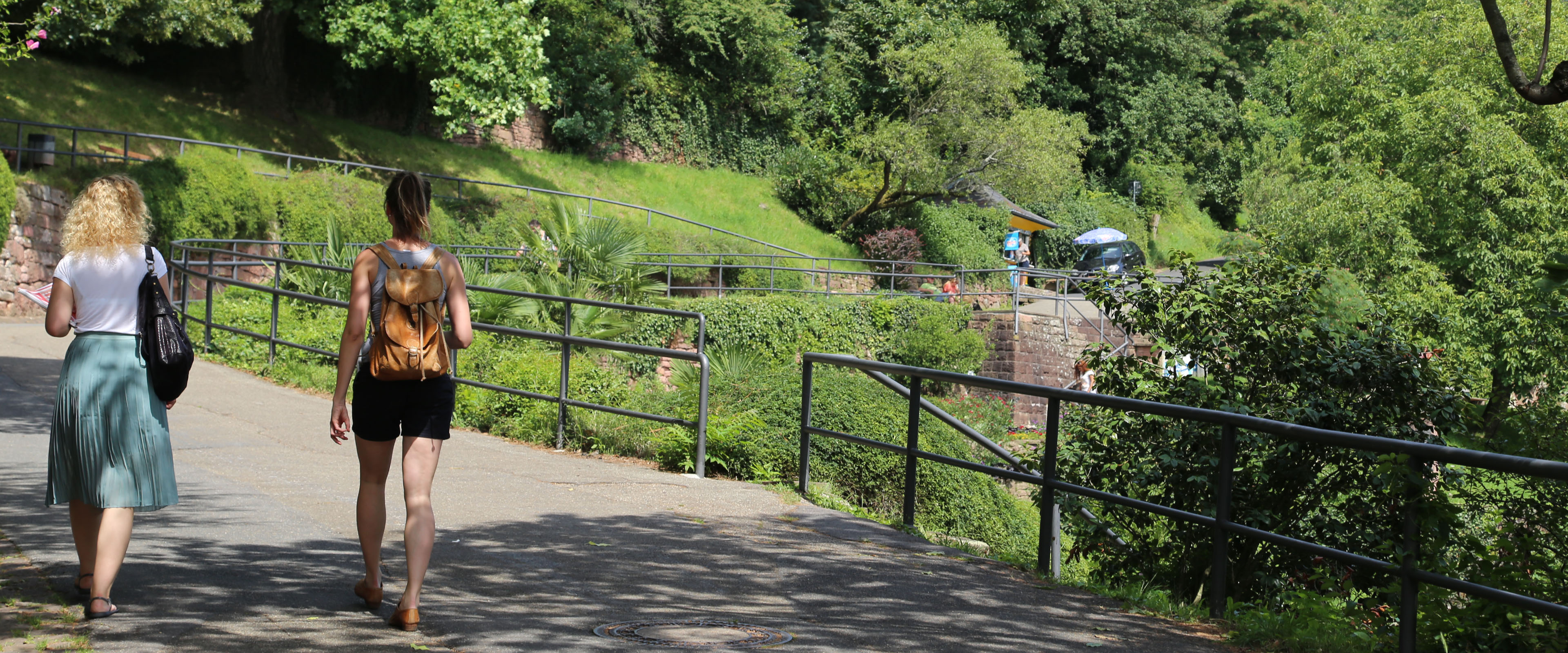 Zwei Spaziergängerinnen von hinten im Sommer auf dem grünen Philosophenweg