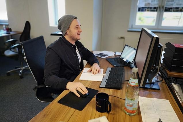 Ein Mitarbeiter sitzt an einem Schreibtisch mit PC (Foto: Ameria AG)
