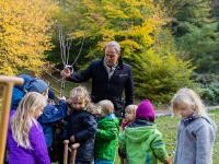 Oberbürgermeister Würzner pflanzt einen Baum, viele Kinder sind dabei und helfen ihm.