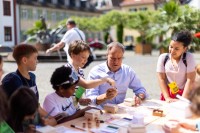 Oberbürgermeister sitzend am Tisch mit Kindern