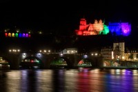 Blick auf das Schloss Heidelberg, dass in Regenbogenfarben angestrahlt wird.