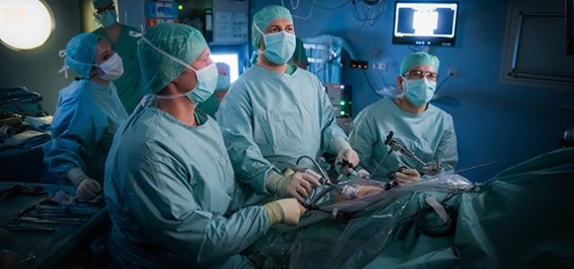 Vier Chirurgen stehen in einem OP-Saal.
