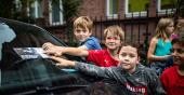 Kinder legen Flyer auf die Windschutzscheibe eines Autos (Foto: Tobias Dittmer)