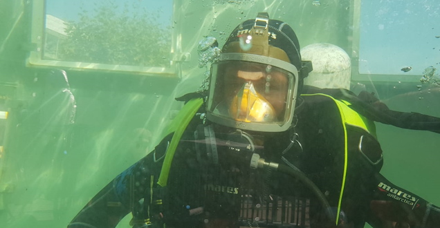 Taucher mit aufgesetzter Maske in einem Wasserbassin