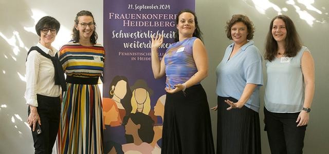 Gruppenfoto vor einem Aufsteller mit der Aufschrift "Schwesterlichkeit weiterdenken"