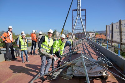 Erster Bürgermeister Jürgen Odszuck und Christian Hemkendreis, DSK, machen eins von 24 Stahlseilen bereit für den Transport mit dem Kran. (Foto: Philipp Rothe) Odszuck und Hemkendreis mit Schutzhelmen auf der Brücke. Sie halten das Ende eines Stahlseils