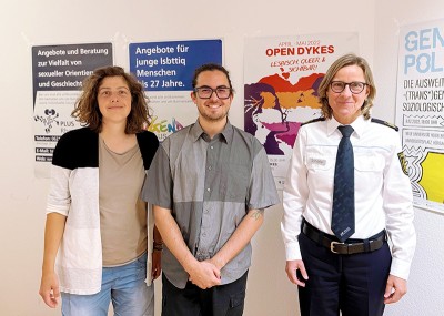 Gemeinsam gegen Queerfeindlichkeit (Foto: Stadt Heidelberg) Schäfer, Emmerich und Hermann vor Plakaten