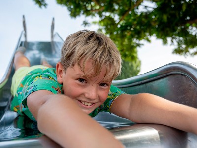 Bahn frei für tolle Ferientage: Der Heidelberger Ferienpass bietet mehr als 150 Angebote für die Sommerferien. Den Pass kann man ab 26. Juni digital kaufen. (Foto: Felix Bäcker) Junge kopfüber auf Rutsche