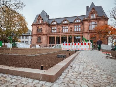 Auf dem Montpellierplatz an der Stadthalle starten in Kürze die Pflanzarbeiten. Zudem werden die Fassaden gereinigt. Bis zur Eröffnung im Februar bleiben die Bauzäune noch stehen. (Foto: Nicolaus Niebylski) Montpellierplatz und Stadthalle. Die Beete sind mit Erde aufgefüllt, ein kleiner Bagger steht daneben