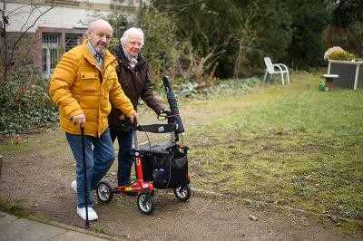 Ob Zugang zum Haus oder barrierefreies Bad: Bei der Beratung werden individuelle Lösungen gefunden. (Foto: Nicolaus Niebylski) Frau mit Rollator und Mann mit Gehstock im Garten