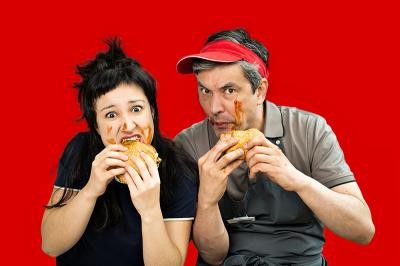 Das Gewinnerstück des „Autor*innenpreises 2025“ wird dieses Jahr nicht nur auf der Bühne zu erleben sein – sondern auch als Hörspielfassung im Radio. (Foto: Susanne Reichardt) Vater und Tochter beißen in Burger, ihre Gesichter sind mit Ketchup verschmiert