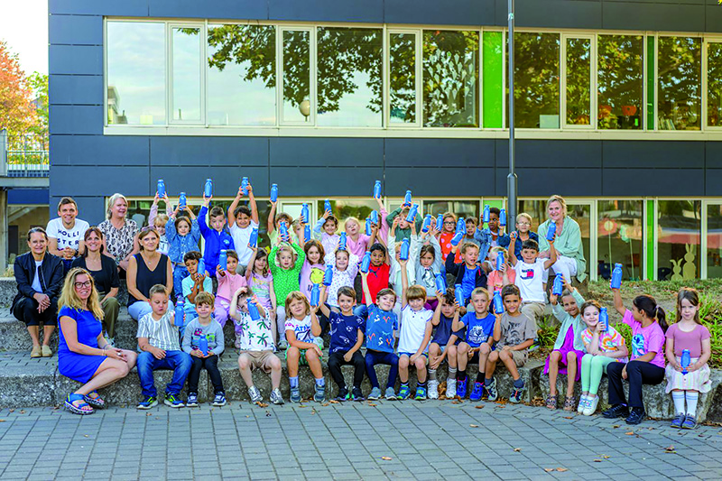 Gruppenfoto, Kinder halten Trinkflaschen in die Höhe