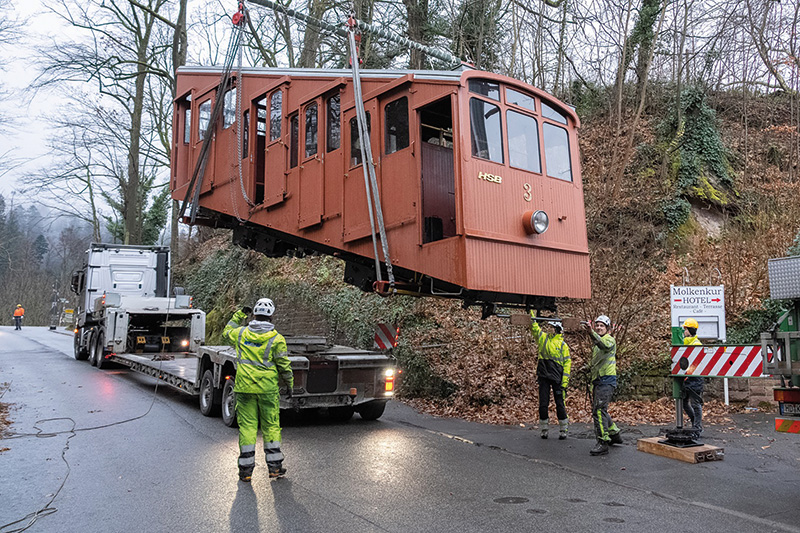 Die obere Bergbahn wird auf den Tieflader gehoben und tritt ihre Reise in die Schweiz an. Dort sorgt ihre Herstellerfirma für eine Generalüberholung.(Foto: Stadtwerke Heidelberg/Christian Buck) Bergbahnwagon schwebt über einem LKW