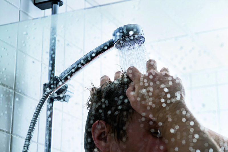Mann wäscht sich Haare unter der Dusche