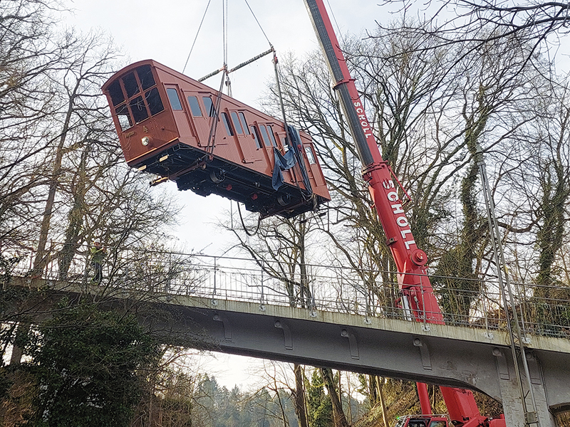 Bergbahnwagon wird von einem Kran in der Luft gehalten