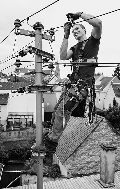 Mann arbeitet an Strommast