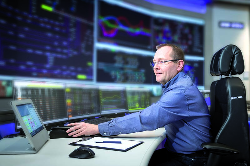 Mann sitzt am Comuter in der Leitstelle 