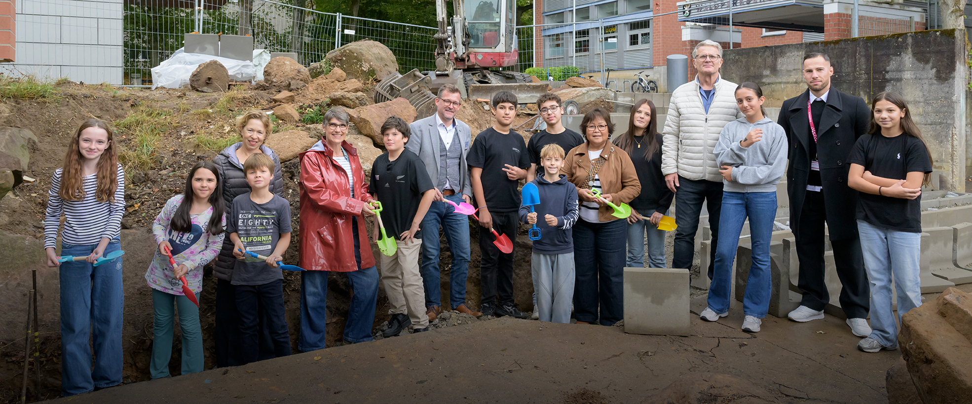 Gruppenfoto mit Sandkastenschaufeln und Bagger